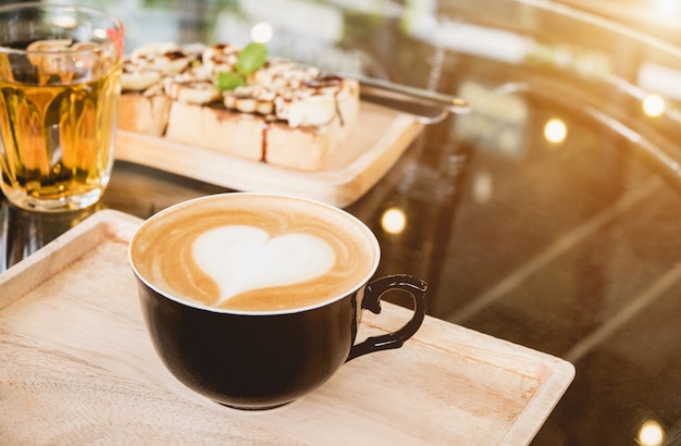 Taza de café negro, café Mocha Ponga en una pequeña bandeja de madera en la cafetería, con iluminación borrosa de fondo bokeh, con un espacio vacío para el texto. concepto relajarse