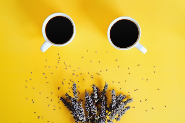 Taza de café negro caliente, croissant dulce. ramo de lavanda. fondo amarillo Vista superior, espacio de copia