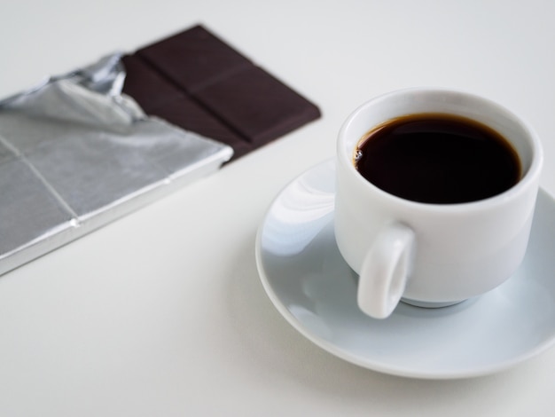 Taza de café negro y chocolate negro en papel de aluminio