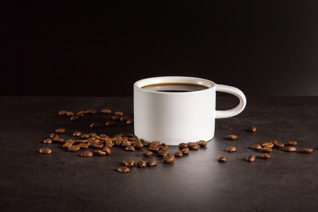 una taza de café negro con granos de café alrededor