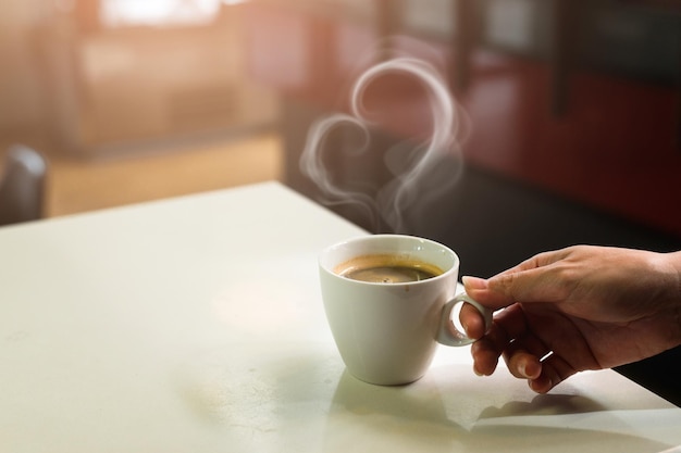 taza de café negro en la mesa blanca