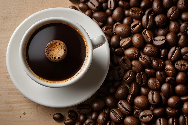 Una taza de café negro una mesa marrón con un montón de granos de café tostados vista superior