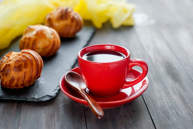 Taza de café negro y pequeños canutillos franceses