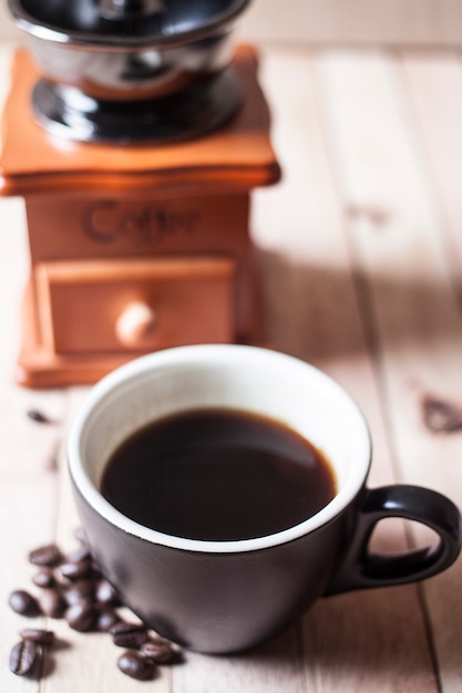 Taza de café negro en el piso de madera