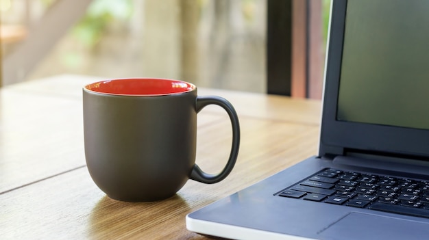 La taza de café negro y portátil.