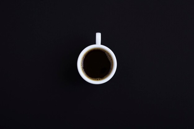 Taza de café negro sobre el fondo negro. Vista superior. Copie el espacio.
