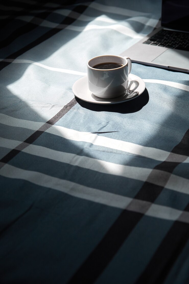 taza de café negro en una taza blanca portátil y la luz de la ventana quédese en casa