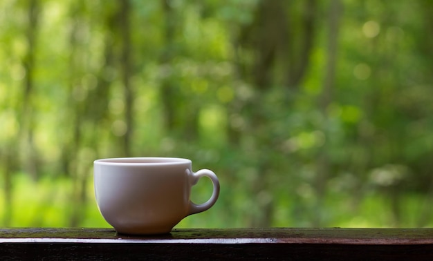 Taza de café o té contra el exuberante follaje Naturaleza concepto relajación