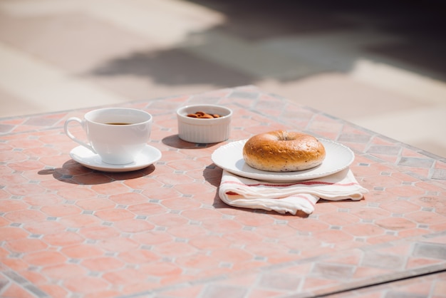 Taza de café con pan en la mesa por la mañana con la luz del sol, desayuno