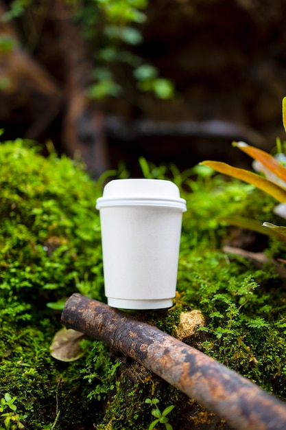 taza de café de papel blanco en la hermosa naturaleza