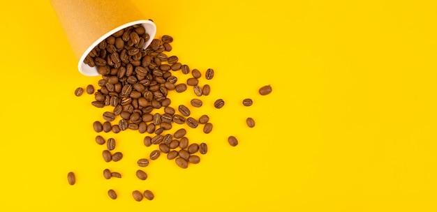 Taza de café de papel con frijoles Fondo amarillo Copiar espacio