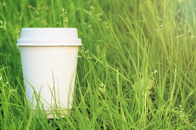 Taza de café de papel en la hierba