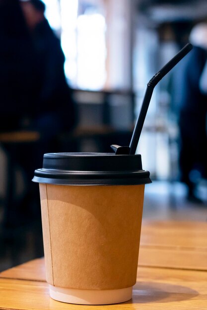 Taza de café de papel en la mesa de una cafetería
