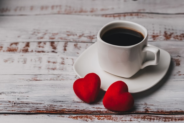 Taza de café y un par de corazones rojos