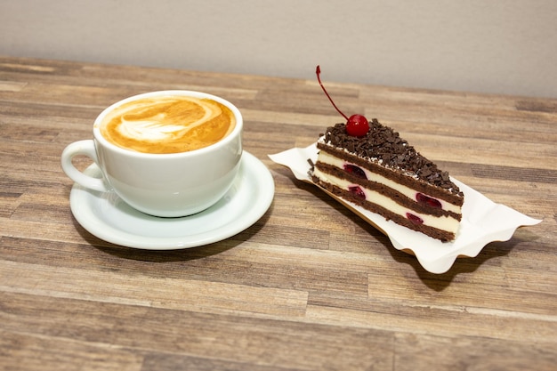 Taza de café y pastel en una mesa de madera Foto de alta calidad