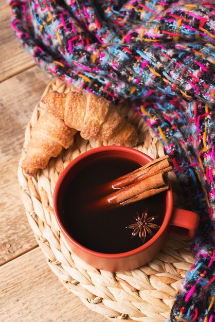 Taza de café y pasteles sobre fondo de madera, humor otoñal