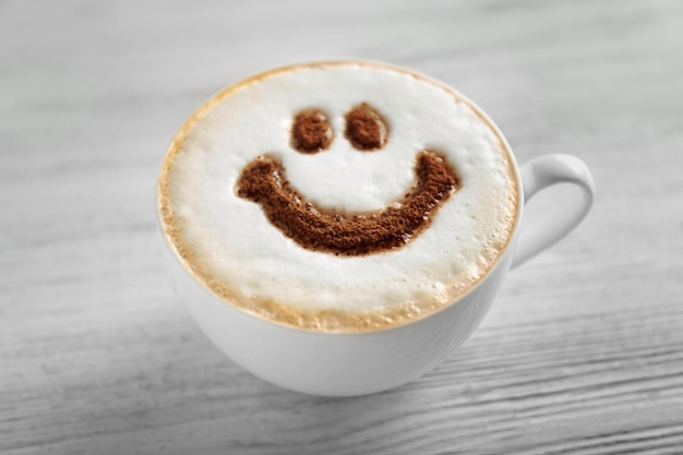 Taza de café con patrón creativo en mesa de madera