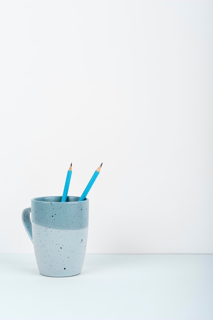 Taza de café de pie en el escritorio Información importante escrita en papel Diferentes suministros de oficina Lápices Plumas Marcadores Teclado de computadora Texto en la mesa de madera