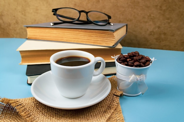 Taza de café y pila de libros en azul