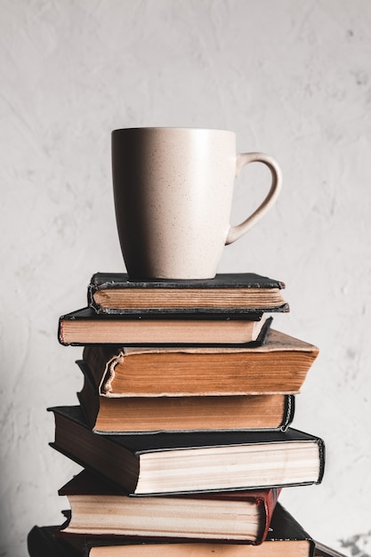 Una taza de café en la pila de libros en gris