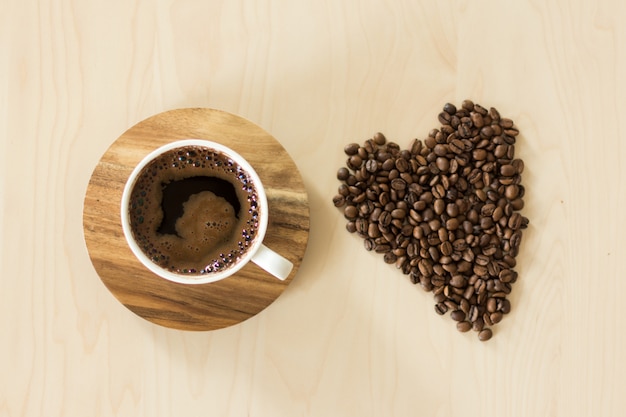 Foto taza de café y platillo en una mesa de madera.