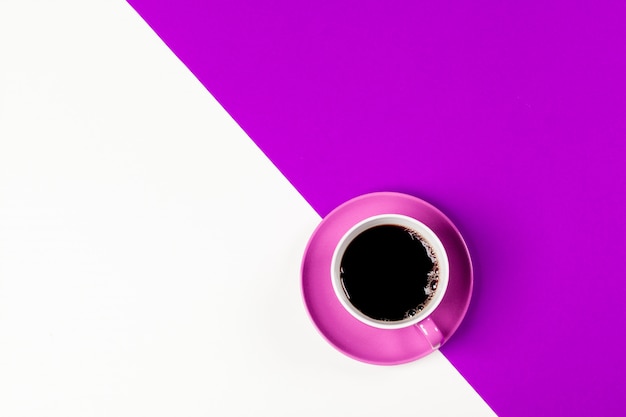Taza de café y platillo sobre fondo de color