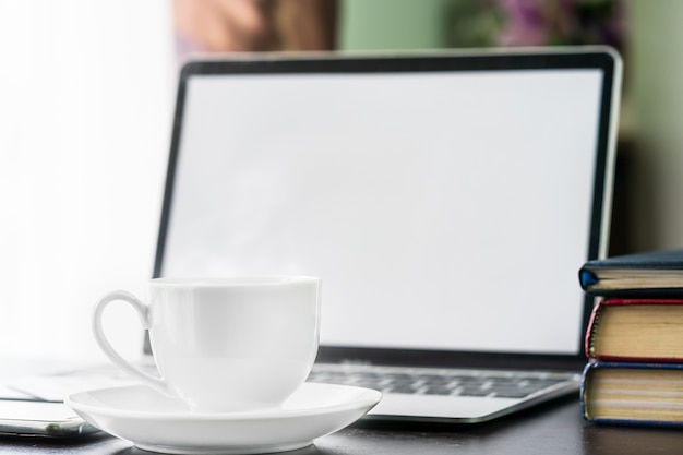 taza de café y portátil en la disposición del escritorio