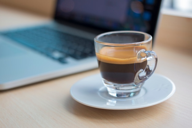 Taza de café y portátil en una mesa