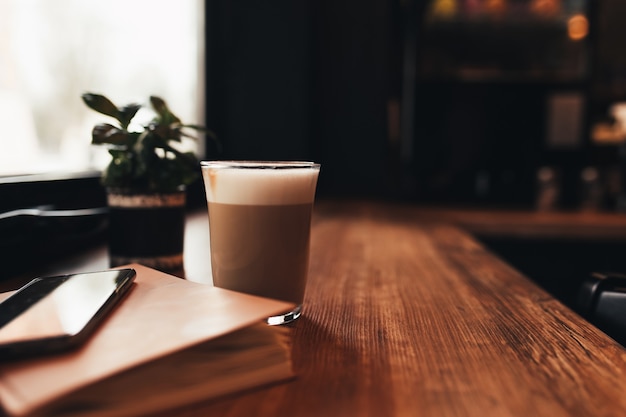 Taza de café, portátil, teléfono en la mesa de café