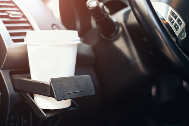 Taza de café en portavasos en el coche.