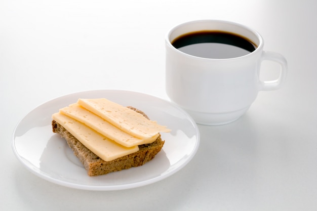 Taza de café y queso con arena para el desayuno.