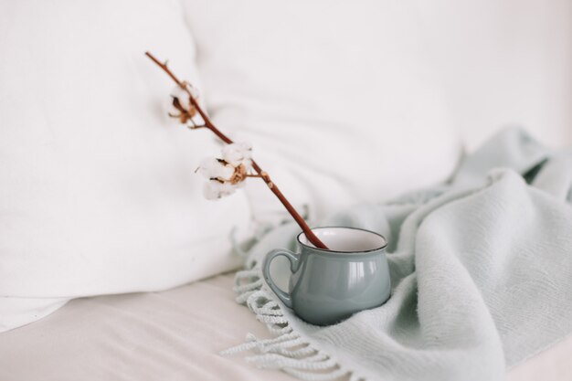 Taza de café y ramitas de algodón desayuno en la cama