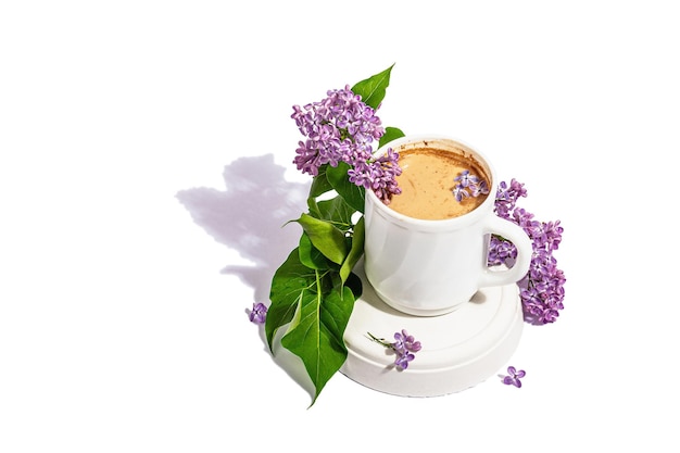 Taza de café y ramo de flores lilas aislado sobre un fondo blanco Concepto de primavera de desayuno