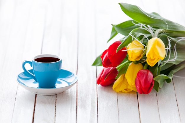 Taza de café y ramo de tulipanes