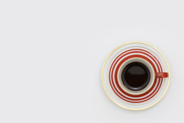 Foto una taza de café con rayas rojas y blancas sobre un fondo blanco.