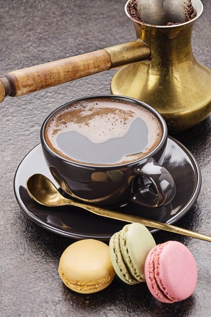 Taza de café recién hecho y macarons