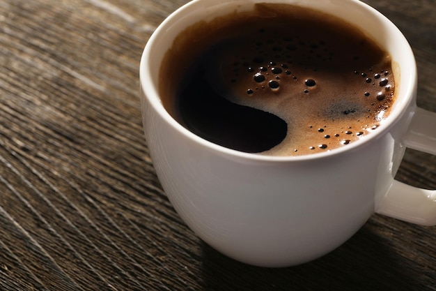 Taza de café recién hecho sobre fondo de madera