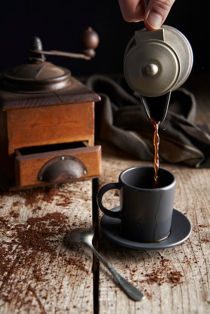 Taza de café recién hecho sobre tabla de madera rústica