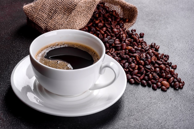 Una taza de café recién perfumado para un comienzo alegre del día. Hermosa taza de café con café en una mesa oscura