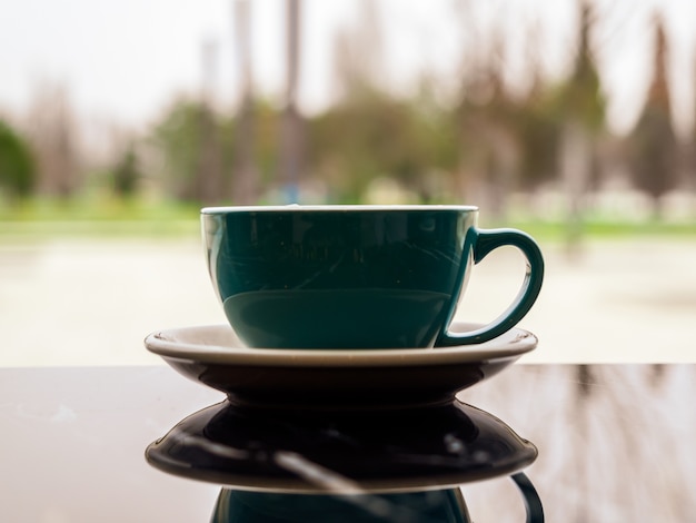 Taza de café con reflejo sobre una mesa