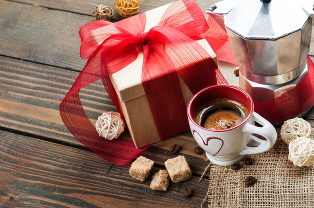 Taza de café, regalo con cinta roja, azúcar morena