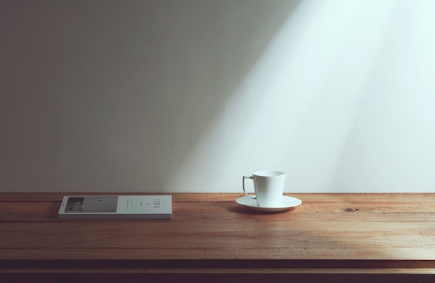 Foto taza de café y revista sobre la mesa