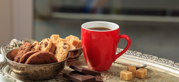 Una taza de café roja en una bandeja vieja