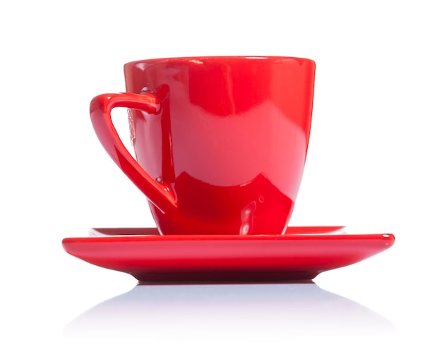 Taza de café roja en platillo aislado