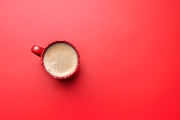 Taza de café roja sobre un fondo rojo.