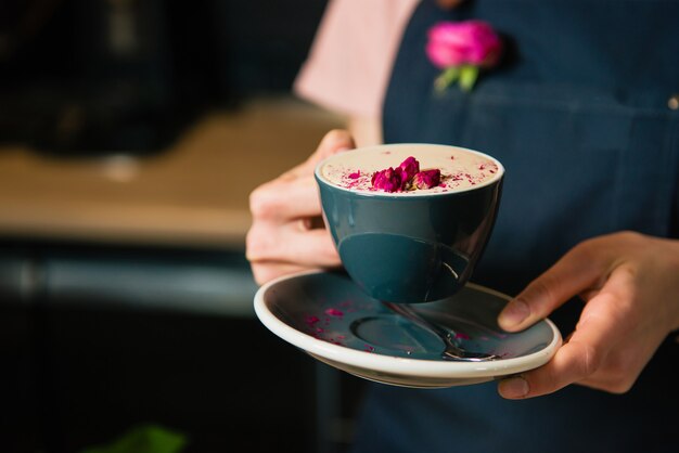 Taza de café rosa raf en manos de barista