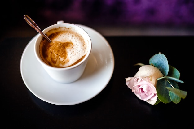 Una taza de café y rosa.