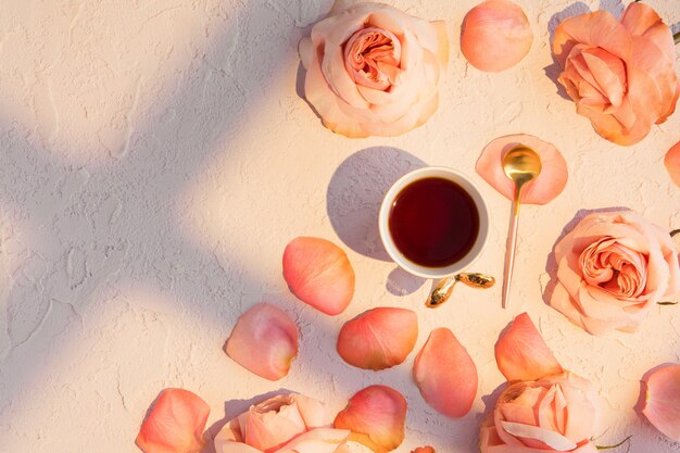 Taza de café con rosas rosas flores y pétalos.