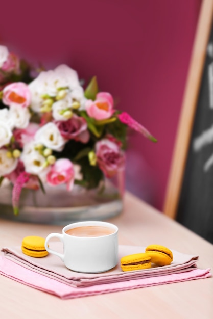 Taza de café sabroso pastel y hermoso ramo de flores en la cafetería