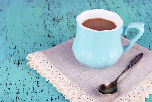 Taza de café con servilleta sobre mesa de madera